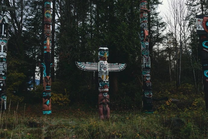 a group of totem poles standing in a forest